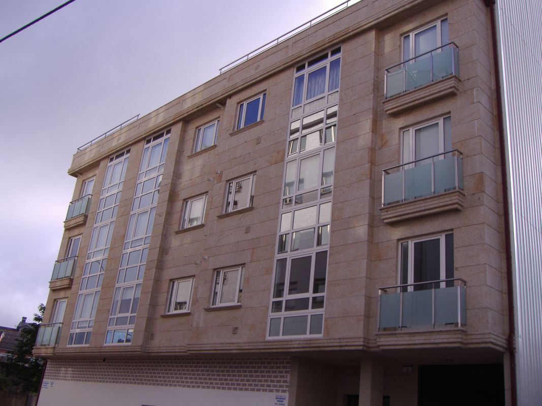 Fachada de edificio con terrazas de vidrio